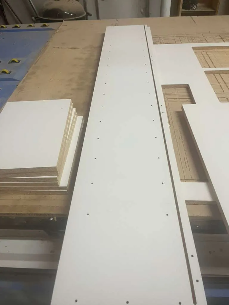 Stack of cabinet side panels next to the CNC table